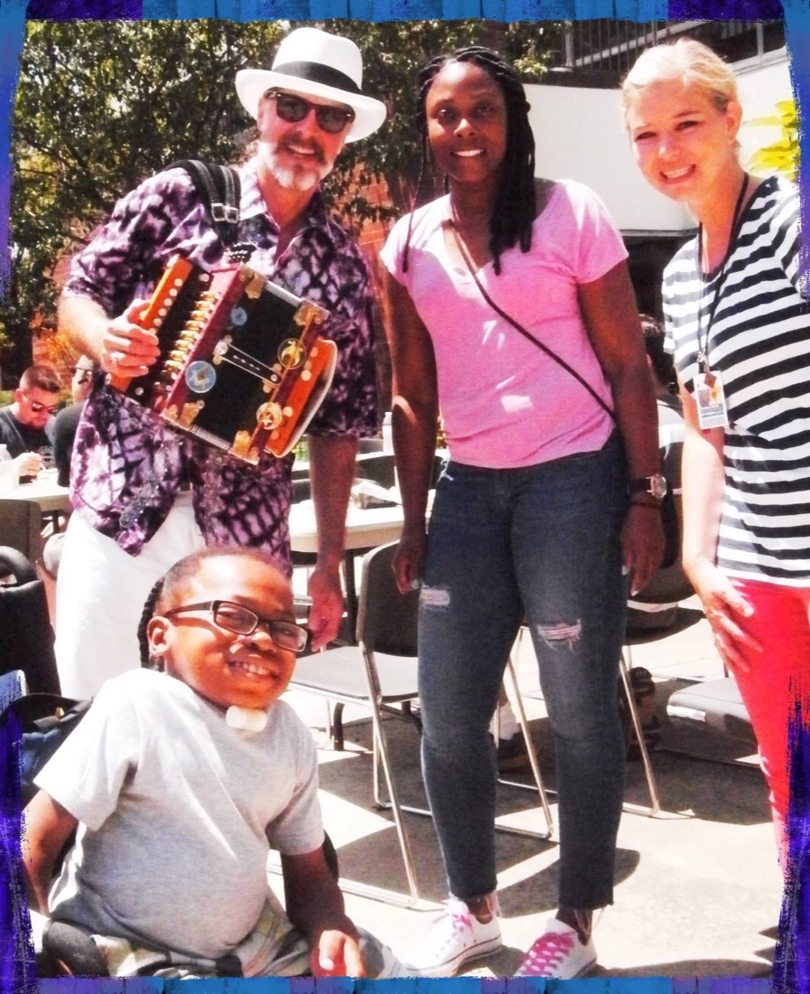 Mister Mojo with a young patient and two family members outside a Shriners hospital.